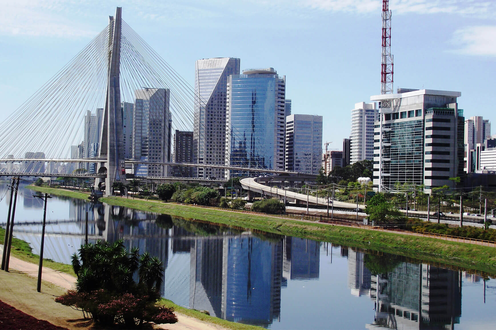 Vista aérea do Brooklin Paulista, onde se vê o rio Tietê em primeiro plano, a ponte Estaiada e, ao fundo, prédios.